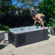 Man interacting with a cold tub in a backyard setting
