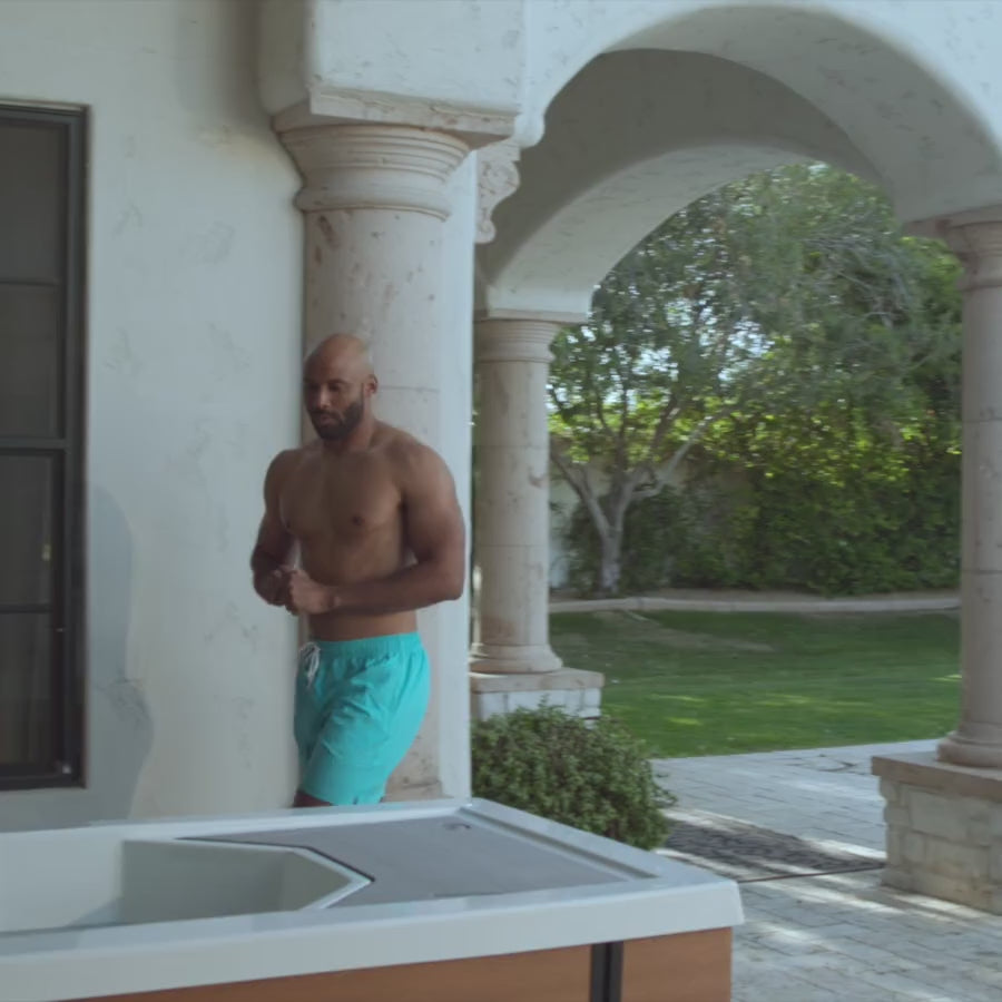 Load video: Video of two people easing themselves into separate cold tubs, exhaling, and smiling
