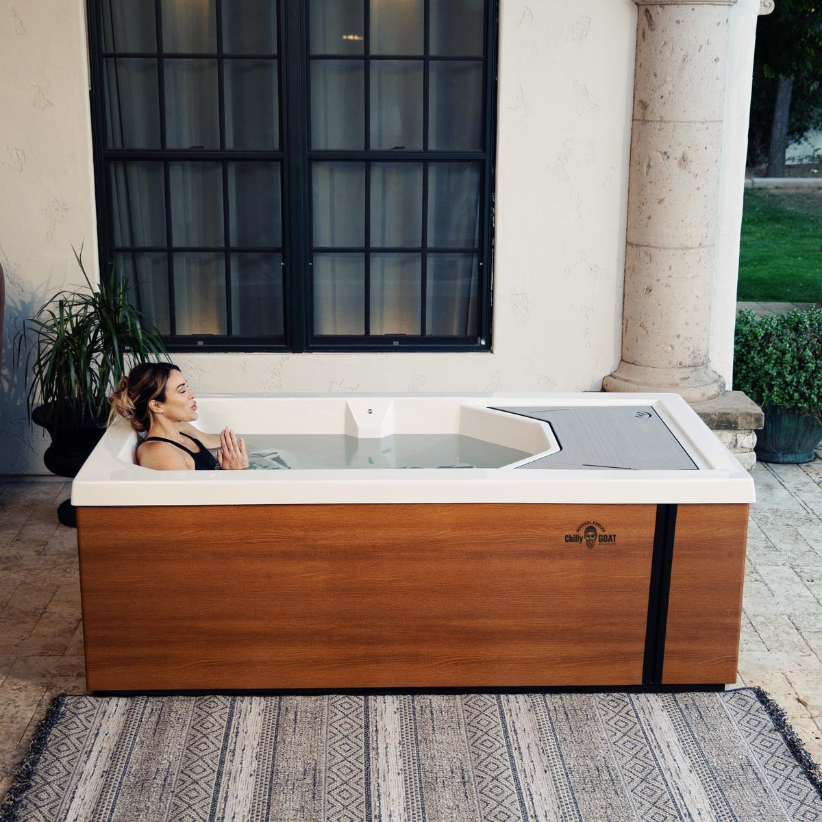 Woman submerged up to chest in cold tub, exhaling